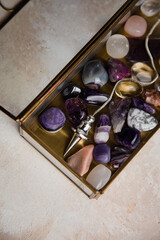 Pendulum and colorful gemstones in a glass box