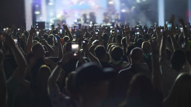 People at a rock concert holding smartphones