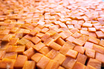 Fresh carrot cube pieces closeup background