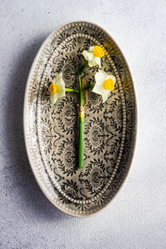 Narcissus flower on a patterned plate