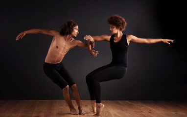 Elegance and balance. A female and male contemporary dancer performing a dramatic pose in front of...