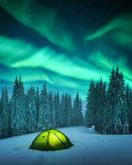 Yellow tent lighted from the inside against the backdrop of incredible starry sky with Aurora...