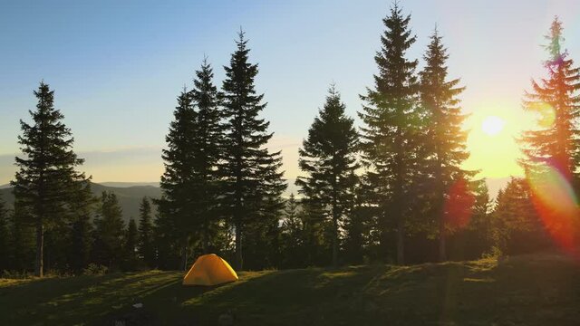 Aerial view of tourist camping tent on mountain campsite at bright sunny evening. Active tourism and hiking concept