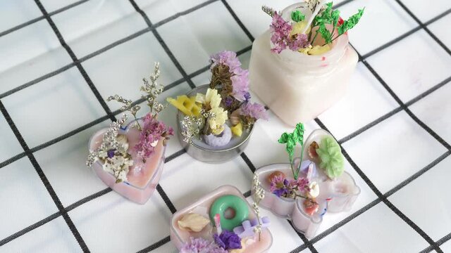 Homemade fragrance candles from soy wax with dry flower, decorative items on table white background. Concept of art, hobby, learning handmade candle, making candles, creative art craft.