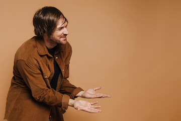 White unshaven man in shirt smiling while holding copyspace