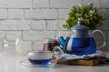 Exotic blue tea teapot and cup on the table. Butterfly pea flower tea, caffeine free herbal beverage has anti-oxidant and an anti-aging effect.