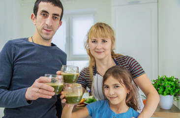 The family is making smoothies in the kitchen. Selective focus.