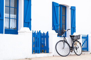 Vélo noir à Noirmoutier et maison à volets bleus - obrazy, fototapety, plakaty