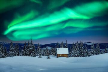 Fantastic winter landscape with wooden house in snowy mountains and northen light in night sky. Christmas holiday and winter vacations concept