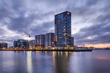Fototapeta premium Rotterdam, The Netherlands, January 17, 2022: Lloydpier neighbourhood with residential buildings between Schiehaven harbour and the river Nieuwe Maas