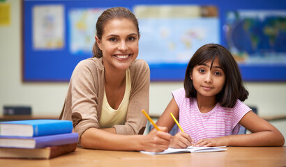 Teaching is her passion. Shot of a teacher helping her student with her work in the classroom.