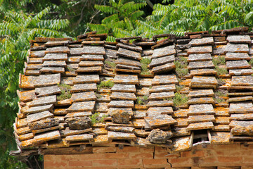 The detail of the old crooked and destroyed roof on the olf village house made of concrete roof...