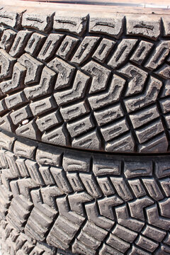 The detail of the tread of two gravel tyres used for rally racing cars. Already used and dirty. 