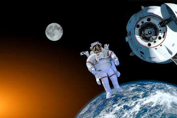 Astronaut spaceman do spacewalk while working near space station in outer space in spacesuit. Earth and Moon on background. Elements of this image furnished by NASA space astronaut photos