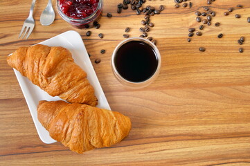 Two croissants for breakfast with jam and coffee