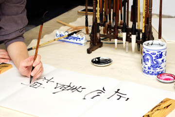 Traditional Chinese calligraphy Master writing a character translation means focus your heart and develop your spirit