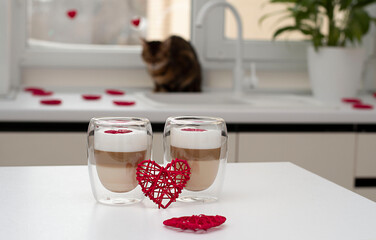 two cups of latte on a background of red hearts