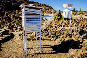 Climate measurement devices at a weather station on white wooden towers on a mountain.