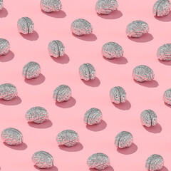 metal human brains on pink background.