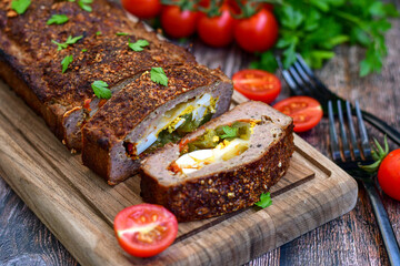 Home made baked  delicious  German meatloaf (Falscher Hase or Hackbraten) is a traditional pork and beef meat loaf bound with boiled eggs and cucumbers