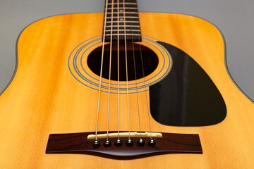  upper soundboard of an acoustic yellow guitar close-up on a gray background