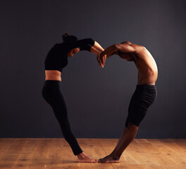 Unity is strength. A female and male contemporary dancer performing a dramatic pose in front of a dark background.