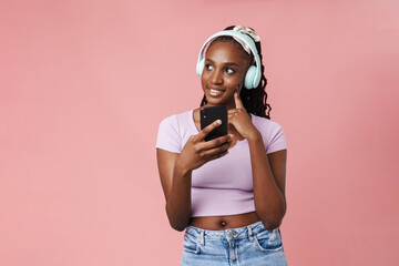 Black young woman listening music with headphones and cellphone
