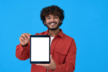 Happy young indian man holding tablet computer showing big mockup white blank empty template screen...