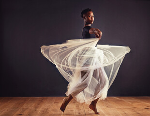 Poetry in motion. Young female contemporary dancer using a soft white white skirt for dramatic...
