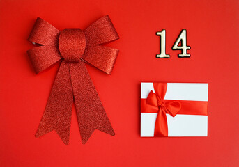 White certificate with red bow and number 14 over it and red big present bow on the red background. Romantic love letter for the Valentine's day concept.