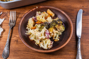 Vegetable stew with broccoli, cauliflower and pumpkin baked with cheese on a plate - healthy mediterranean cuisine