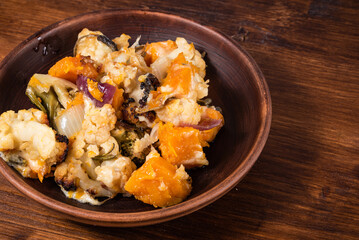 Vegetable stew with broccoli, cauliflower and pumpkin baked with cheese on a plate - healthy mediterranean cuisine