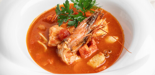 Seafood soup in white plate macro close up