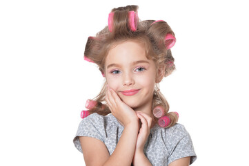 portrait of emotional little pretty girl with hair curlers