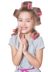 portrait of emotional little pretty girl with hair curlers