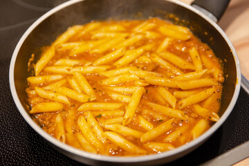 penne pasta with bolognese sauce in a pan