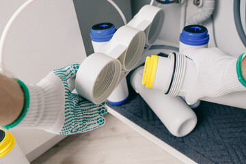 Plumber working change cartridge filter for water in white kitchen. Concept filtration system