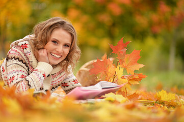 Portrait of beautiful young woman reading in park