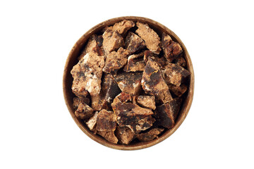 Pieces of raw unrefined cane sugar in wooden bowl, isolated on a white. Top view.