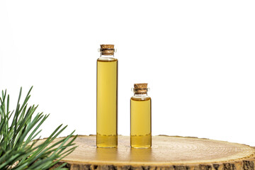 Two glass jars with yellow oil and pine plant extract on a tree cut. White background. Place for inscriptions and text.	
