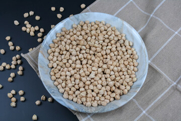 Raw chickpeas on the plate and towel top view.