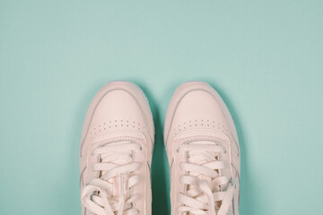 New white sport sneakers shoes on blue purple background. Flat lay, top view. Banner