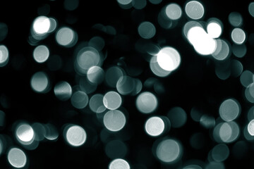 Blurred abstract green glitter texture. Many defocused bokeh christmas green lights on black...