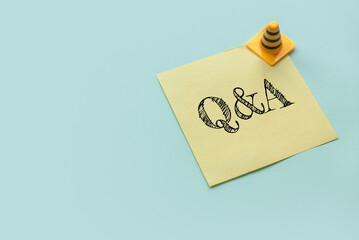 Copy space background with a yellow color empty sticky paper note written with Q&A or Questions and...