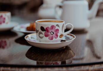 A cup of tea on the glass table on a veranda of a summer cafe