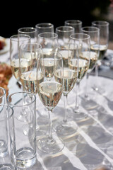Sparkling glassware with wine and champagne on dinner table in restaurant, copy space. Crystal glasses ready for celebration. Wineglasses at luxury wedding reception