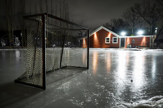 Hockey Net On Empty Outdoor Skating Rink At Night With Empty Space