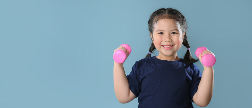 Healthy asian child girl playing dumbbell with strong look healthy. childhood kindergarten kid with strong muscle and good emotion.Happy kid with healthcare.Pediatric, Vaccine, protect virus.