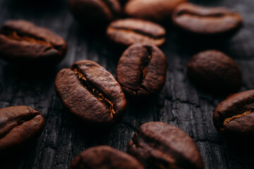 Close-up of coffee beans. Selective focus. Macro photo of coffee on dark textural background. Painting in a coffee shop or restaurant