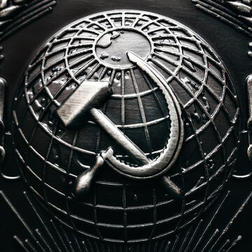 Symbol of great and mighty country. Hammer and sickle against background of globe of earth. Coat of arms of communist country Union of Soviet Socialist Republics. Close-up. Background.